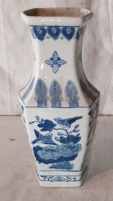 un vase bleu et blanc posé sur une table