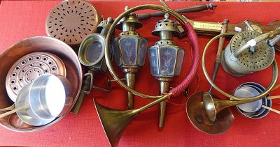 une table rouge sur laquelle sont posés plusieurs objets en laiton