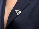 a close up of a woman wearing a suit with a broochet on her lapel