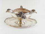 a silver plate with a silver saucer on it