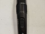 a close up of a black hair clipper on a white surface
