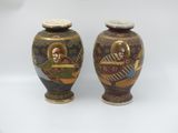pair of asian vases with a painting of a man and a woman on them