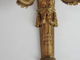 a gold wall sconce on a white wall