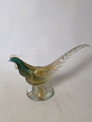 a glass bird that is sitting on a glass stand
