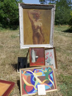 une photo d'une femme debout dans un champ, à côté d'un tableau