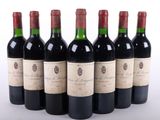 six bouteilles de vin rouge alignées sur une surface blanche