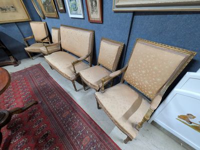 four chairs and a table in a room with pictures on the wall