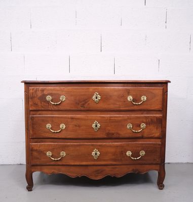 une commode en bois avec des poignées et des boutons en laiton
