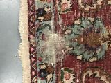a close up of a red and blue rug on a gray surface