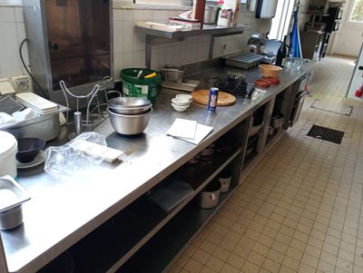 une cuisine avec beaucoup de casseroles et de poêles sur le comptoir