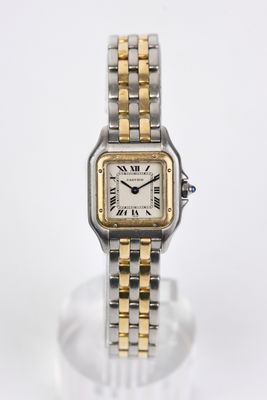 un gros plan d'une montre sur une surface claire avec un fond blanc