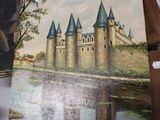 a painting of a castle on a table next to other items