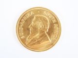 gros plan d'une pièce d'or sur une surface blanche