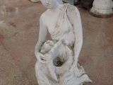 une statue représentant une femme tenant une fleur dans ses mains