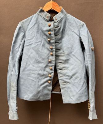 une vieille veste bleue suspendue à un cintre en bois