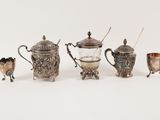 a group of silver and glass items on a white surface