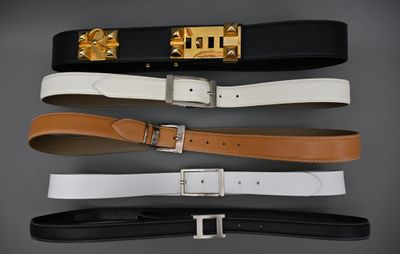 three belts with gold buckles on a gray background