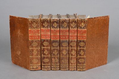 three old books are stacked on top of each other on a table