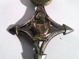 une photo d'une broche en métal ornée d'une étoile et d'une couronne