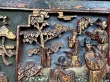 a wooden carving of a man and a woman in a garden