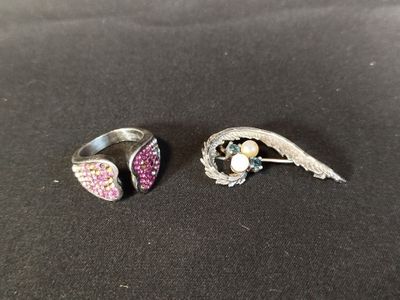 deux bagues en argent ornées de pierres roses et blanches, posées sur un fond noir