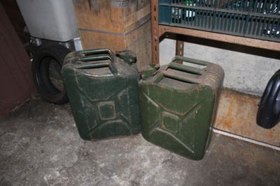 two green jerry cans sitting next to each other on the floor