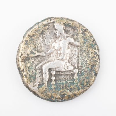 an old silver coin with a man sitting on a bench
