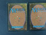 two decks of magic the gathering are shown on a black surface