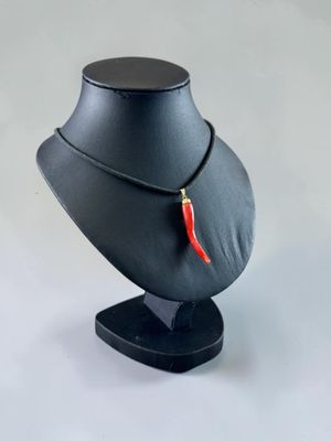 necklace with a red chili on a black stand
