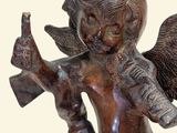 a statue of an angel holding a bottle and a cell phone