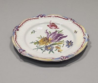 FAIENCE DE L'EST (XXe). Assiette chantournée en faïence poly…