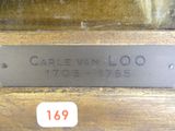 la plaque signalétique d'une statue en bronze représentant un homme, posée sur une table en bois