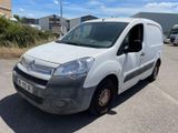 the white van is parked in a parking lot near a building