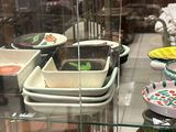de nombreux bols et casseroles exposés dans une vitrine