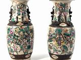pair of chinese vases with floral designs on them against a white background