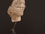sculpture of a head on a wooden base on a table