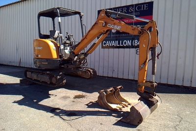 a small excavator that is parked outside of a building