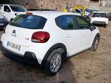 a small white car parked in a parking lot