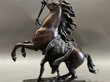 statue of a horse with a rider on it ' s back on a rock