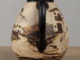 a brown and black vase sitting on a table