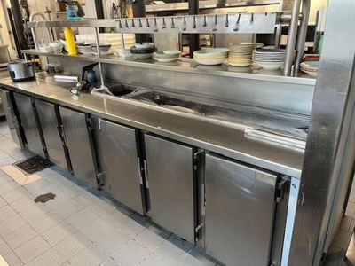 a large stainless steel kitchen with many dishes on the counter