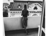 photographie en noir et blanc d'une femme assise sur un balcon
