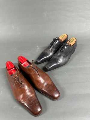two pairs of brown shoes with red soles on a gray surface