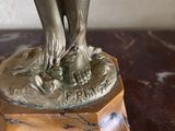 a bronze statue of a woman holding a flower
