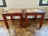 une paire de tables d'appoint en bois avec des plateaux en marbre, posées sur un parquet