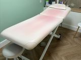 a white table with a pink blanket on it in a room
