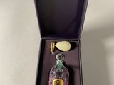 perfume bottle in a purple box on a white surface