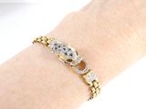 a woman ' s arm with a gold bracelet and a diamond watch