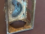 une boîte en métal posée sur une table, avec un oiseau à l'intérieur