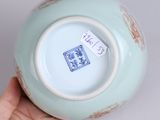 a hand holding a blue and white vase that has a sticker on it